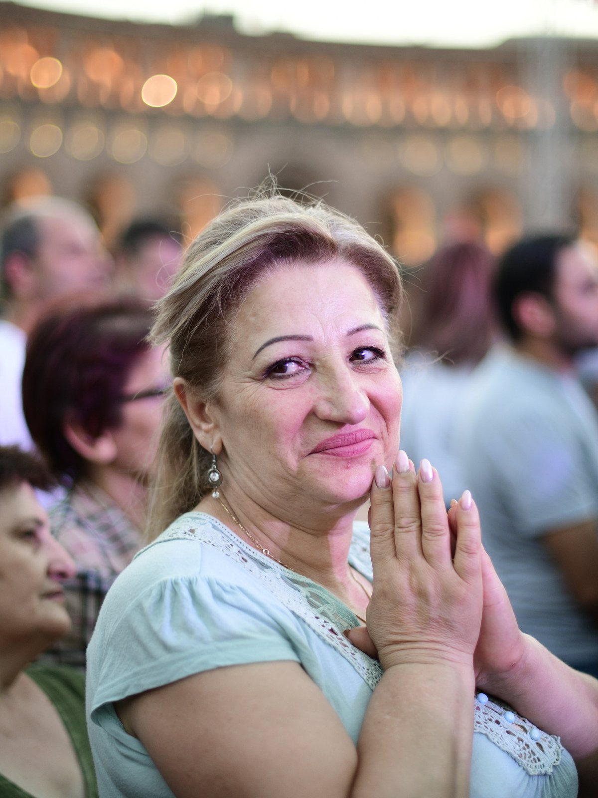 A woman smiles with her hands pressed together, Yerevan