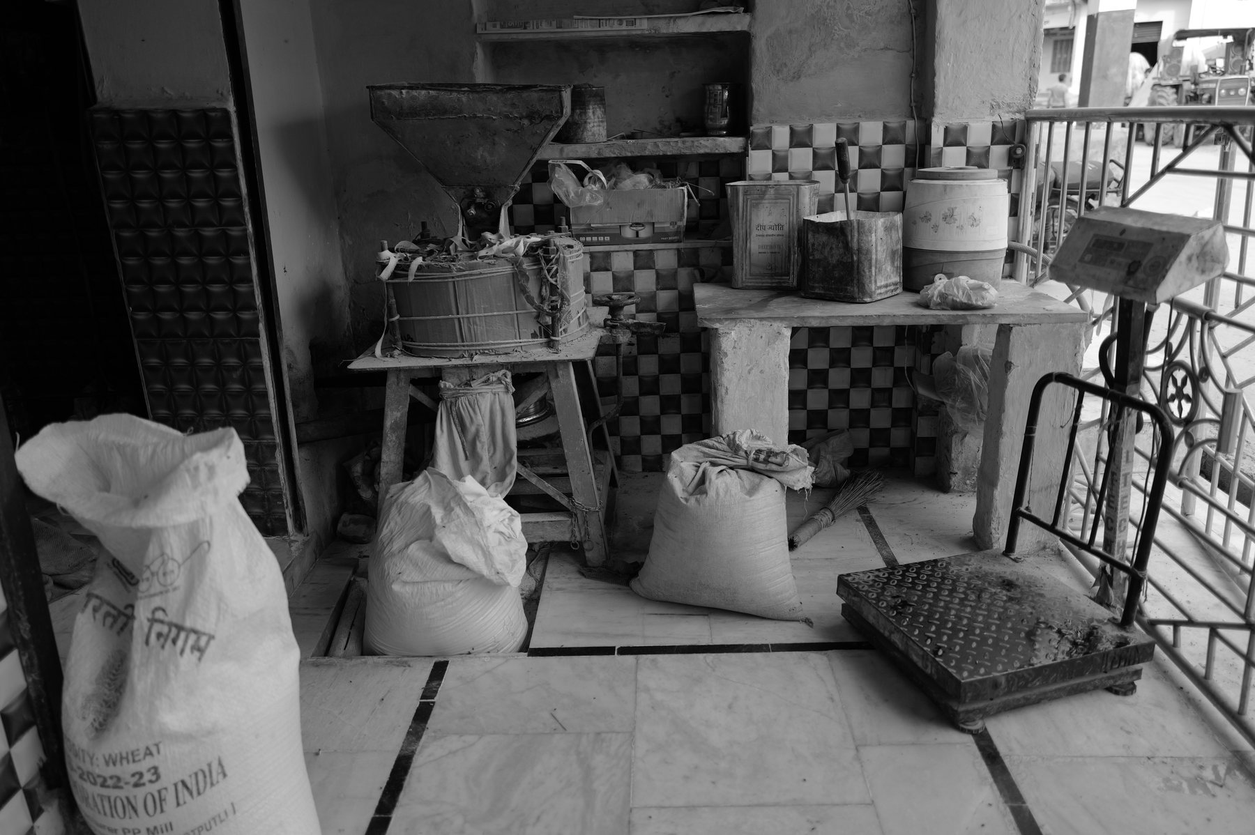 Sacks of grain and tins stacked on a tiled floor